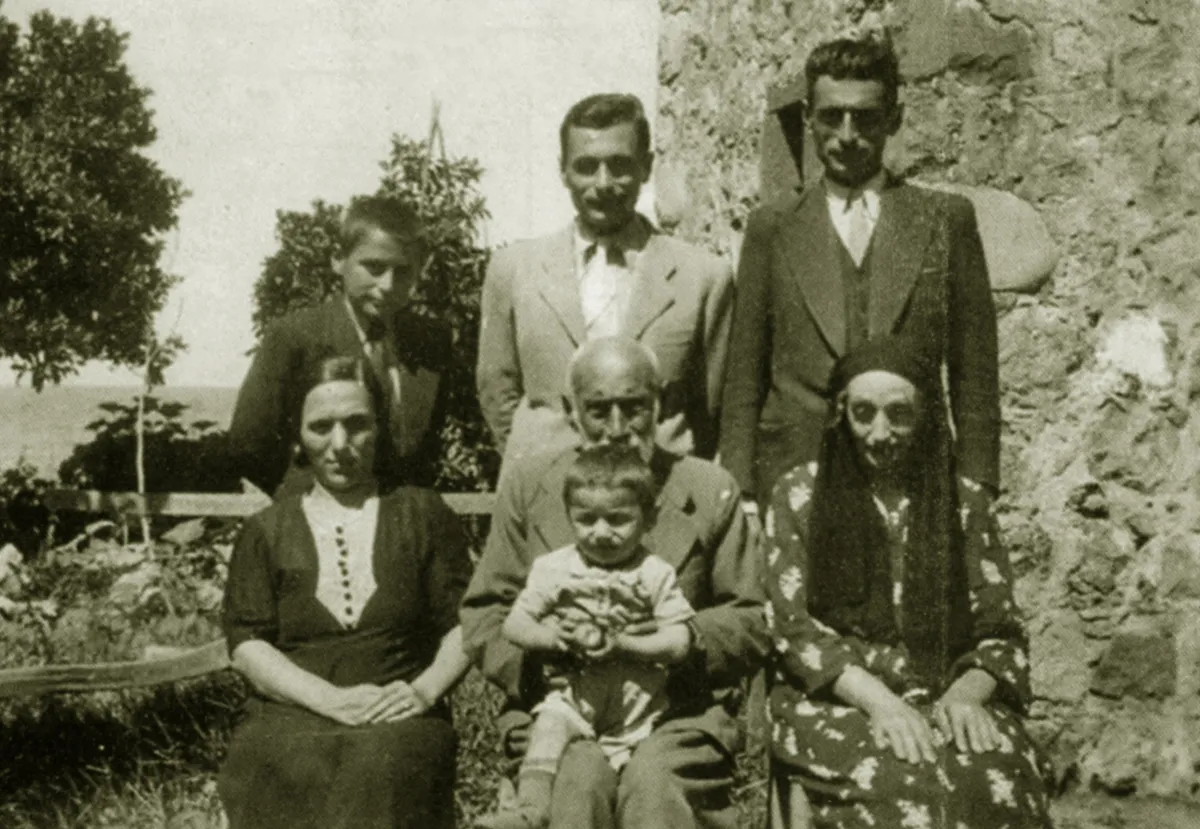 Ayaktakiler; sağ başta Süleyman Kazmaz’ın ağabeyi Mustafa Asım, ortada Süleyman Kazmaz, sol başta kardeşi Mahmut Esat Kazmaz. Oturanlar; sağ başta annesi Hüsniye, ortada babası Hacı Hafız Osman, kucağında torunu Kemal, sol başta Mustafa Kazmaz’ın eşi Saime; Çayeli’nde evlerinin bahçesinde.